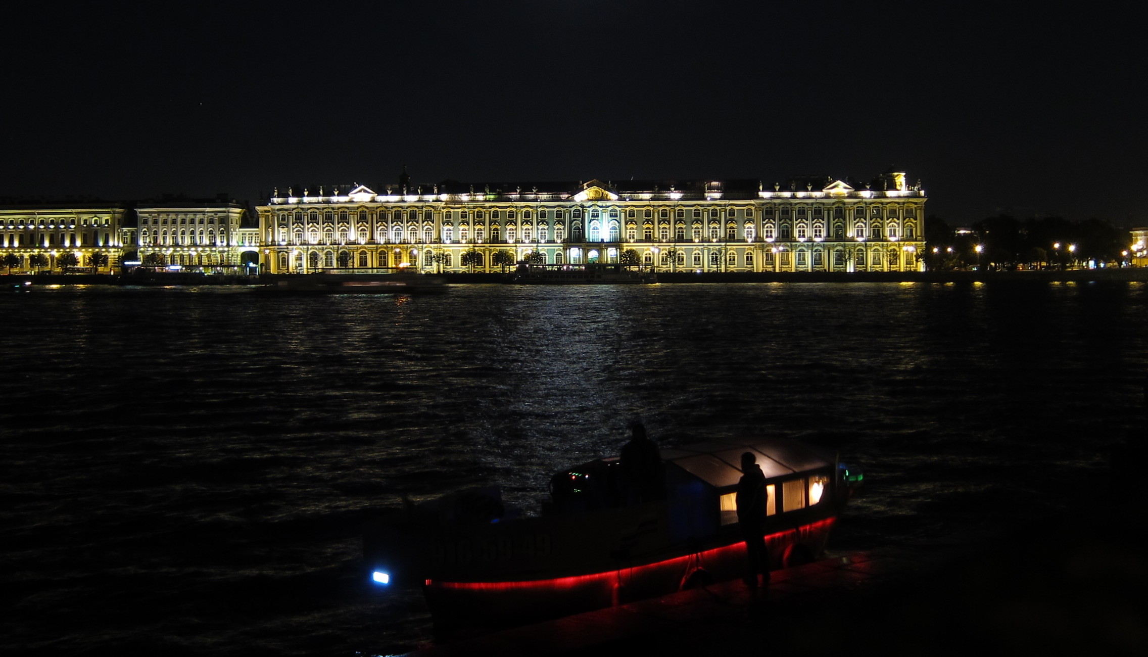 Winter Palace at night, a boat in front.